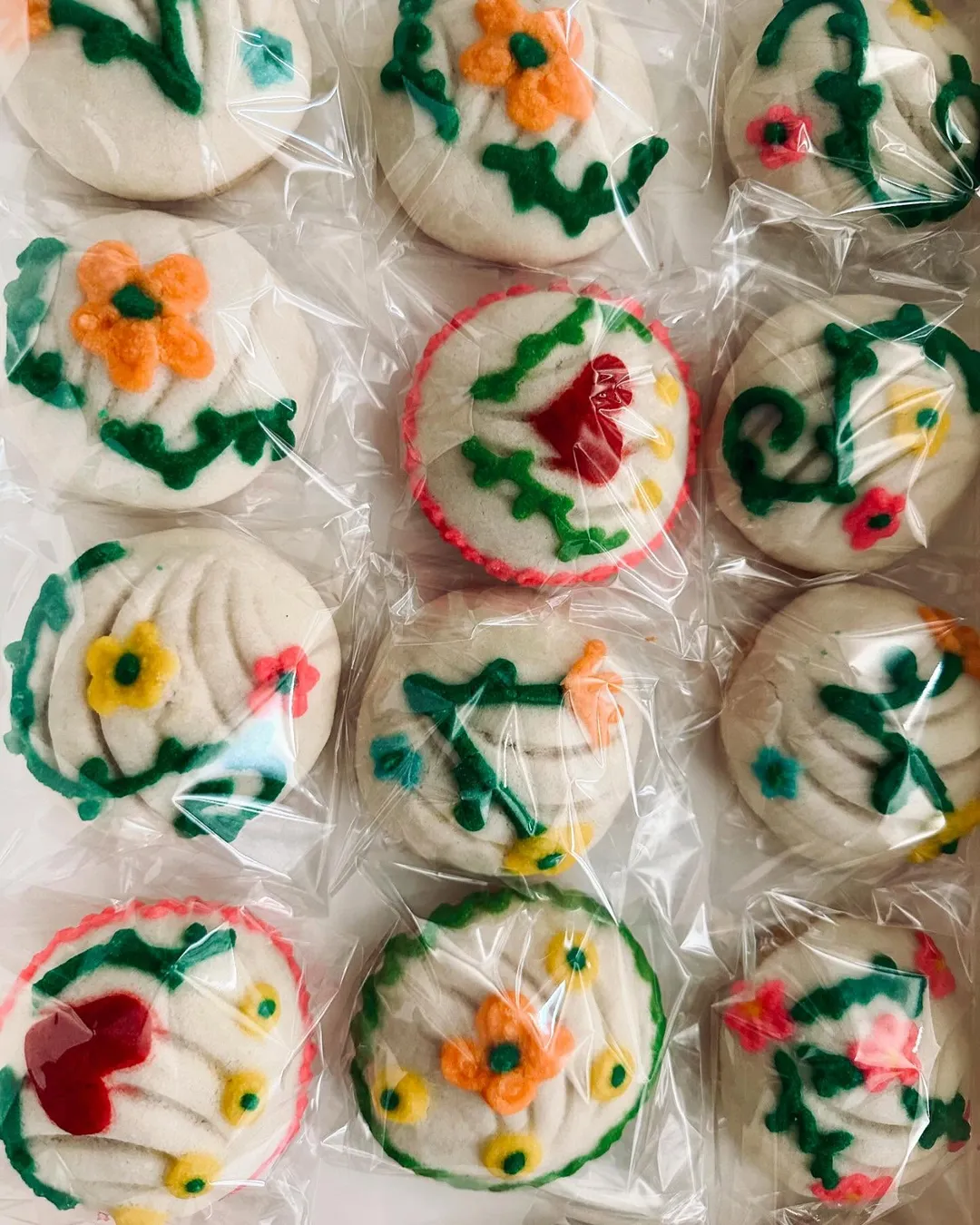 Hand-piped floral conchas in red, orange and green, individually wrapped